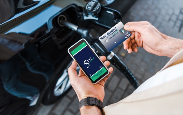 hand holding mobile and card at gas pump